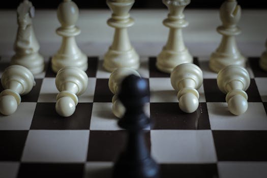 Close-up of white chess pieces toppled on a chessboard, symbolizing defeat.